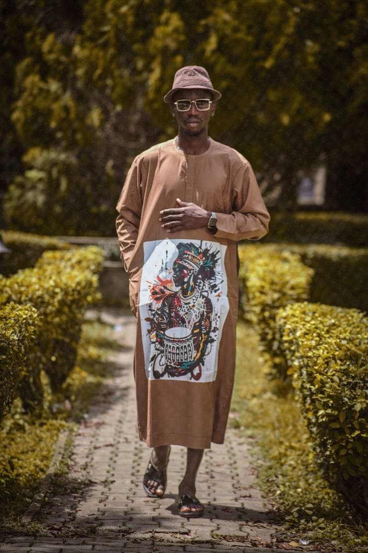 Man in a camel kaftan with a drummer graphic panel