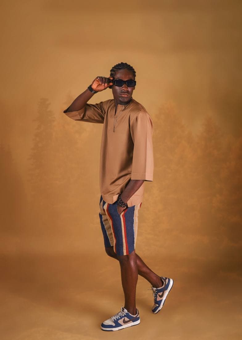 Man in a camel tunic and aso-oke shorts