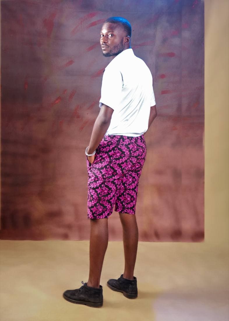 Man in a white shirt and magenta floral-print shorts